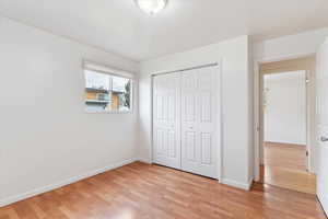 Unfurnished bedroom with light wood-style floors and a closet