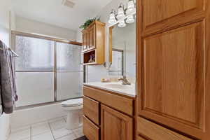 Full bathroom with vanity, combined bath / shower with glass door, and light tile patterned flooring