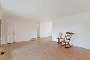 Sitting room featuring light wood-type flooring and baseboards
