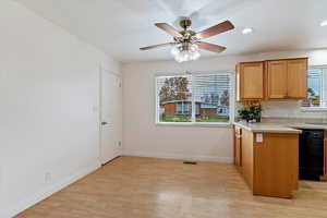 Kitchen featuring light countertops, brown cabinets, light wood-style flooring, dishwasher, and recessed lighting