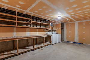 Unfinished below grade area with washer and clothes dryer