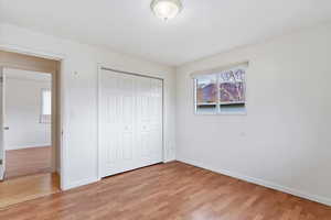 Unfurnished bedroom with light wood-style flooring and a closet