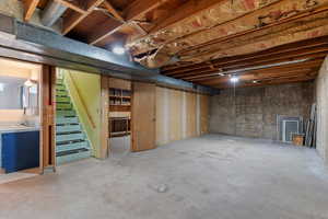 Unfinished below grade area featuring stairway and a sink