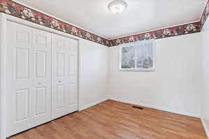 Unfurnished bedroom featuring a closet and light wood-type flooring