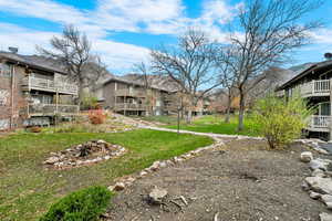 View of community featuring a yard, a residential view, and a balcony