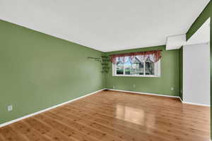 Unfurnished room with wood finished floors and a textured ceiling