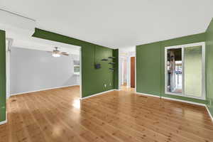 Empty room featuring healthy amount of natural light, hardwood / wood-style floors, and ceiling fan