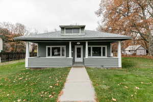 Bungalow-style home with covered porch and a shingled roof