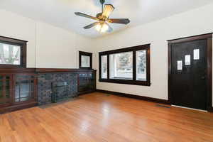 Unfurnished living room with a fireplace, light wood-style floors, and ceiling fan