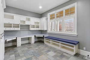 Mudroom featuring baseboards and light stone finish flooring