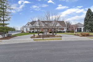 View of front of home with curved driveway and a front lawn