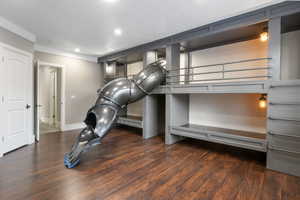 Exercise room with dark wood finished floors and recessed lighting