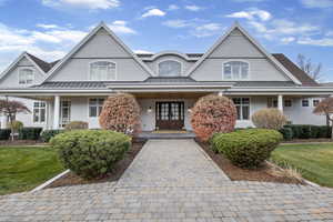 Shingle-style home with a standing seam roof, a metal roof, and covered porch