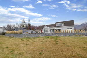 Back of house with a yard and a patio