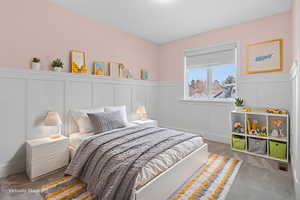 Bedroom with a decorative wall and a wainscoted wall