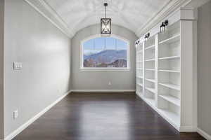Unfurnished room with dark wood-style floors, lofted ceiling, and a mountain view