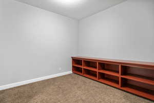 Empty room with baseboards and light colored carpet
