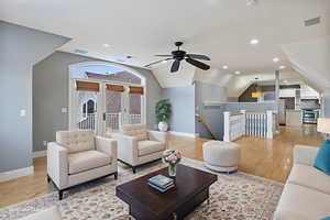 Living area featuring vaulted ceiling, recessed lighting, and light wood-style flooring