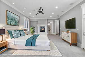 Bedroom with ornamental molding, recessed lighting, a glass covered fireplace, carpet floors, and ensuite bathroom