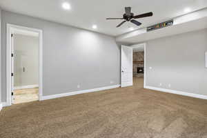 Unfurnished room featuring a ceiling fan, a fireplace, carpet, and recessed lighting