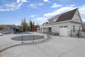 Back of house with a patio area, a shingled roof, driveway, and a garage