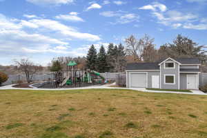 View of playground with an outbuilding and a fenced backyard