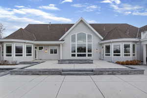 Back of property featuring a patio and roof with shingles