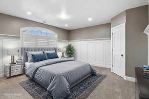 Bedroom featuring a decorative wall, a wainscoted wall, and light carpet