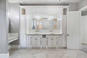 Full bathroom with double vanity, decorative backsplash, and a chandelier