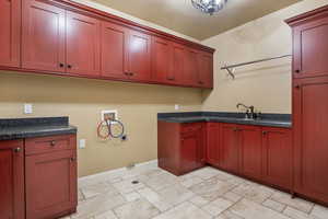 Washroom featuring hookup for a washing machine, gas dryer hookup, hookup for an electric dryer, and cabinet space