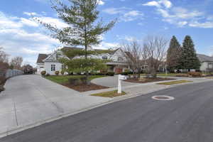 View of front of property with driveway and a front lawn