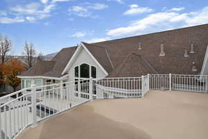 Rear view of house featuring a shingled roof and a patio