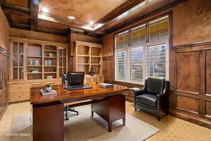 Office space featuring coffered ceiling, beam ceiling, light flooring, and crown molding