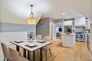 Dining space featuring light wood-type flooring, recessed lighting, and lofted ceiling