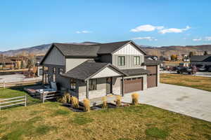 Modern farmhouse with board and batten siding, roof with shingles, and a mountain view