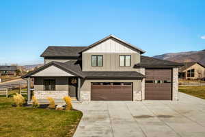Modern inspired farmhouse with a shingled roof, a mountain view, and board and batten siding