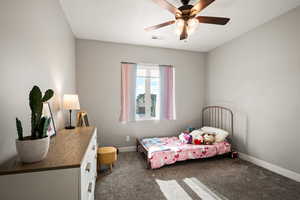 Bedroom with dark colored carpet and ceiling fan