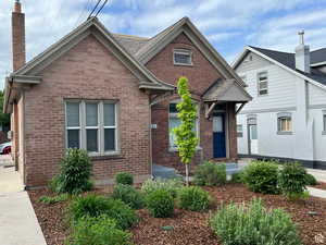 View of front of house with brick siding and a chimney