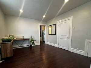 Empty room with dark wood-style flooring, recessed lighting, cooling unit, and a textured ceiling