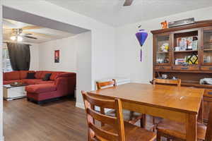 Dining space featuring ceiling fan, a textured ceiling, and wood finished floors