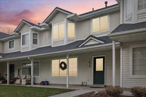 View of front of house featuring roof with shingles and a porch