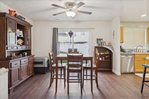 Dining area with dark wood-type flooring and a ceiling fan