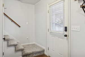 Doorway to outside featuring stairway and baseboards