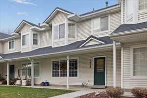 View of front of house with roof with shingles and a porch