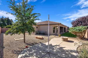 Back of house with a fire pit, a patio, stucco siding, a fenced backyard, and a tile roof