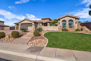 Mediterranean / spanish house with stone siding, stucco siding, driveway, a tiled roof, and an attached garage