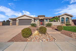 Mediterranean / spanish-style house with stone siding, stucco siding, a garage, and driveway