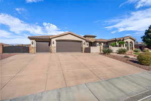 Mediterranean / spanish house with stone siding, a gate, stucco siding, and an attached garage