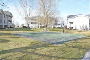 View of basketball court featuring community basketball court, a yard, and a residential view