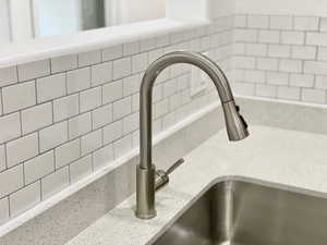 Kitchen view of light stone counters and a sink